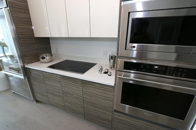 kitchen featuring white cabinetry, backsplash, and appliances with stainless steel finishes