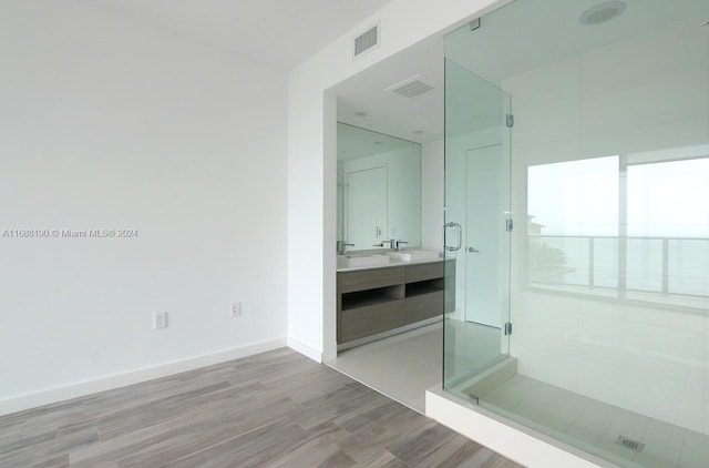 bathroom featuring an enclosed shower, vanity, and hardwood / wood-style floors