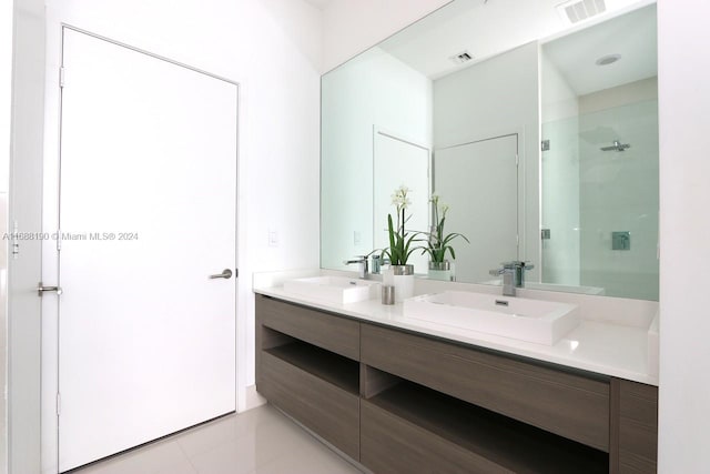 bathroom featuring tiled shower, vanity, and tile patterned floors