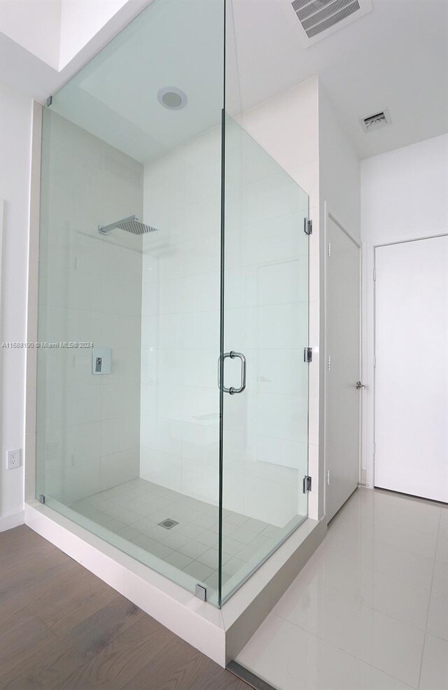 bathroom with walk in shower and hardwood / wood-style floors