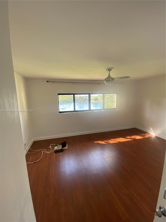 spare room with dark wood-type flooring and ceiling fan