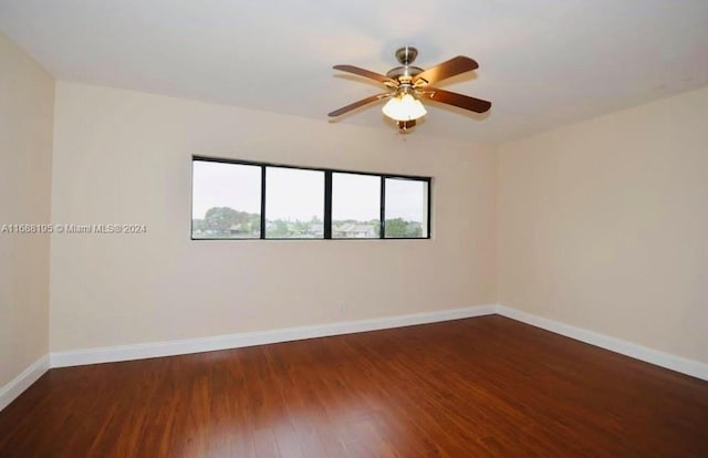 unfurnished room with dark wood-type flooring and ceiling fan