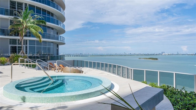 view of pool with a patio and a water view