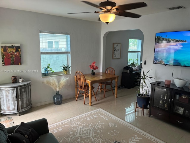 tiled living room with ceiling fan and a healthy amount of sunlight