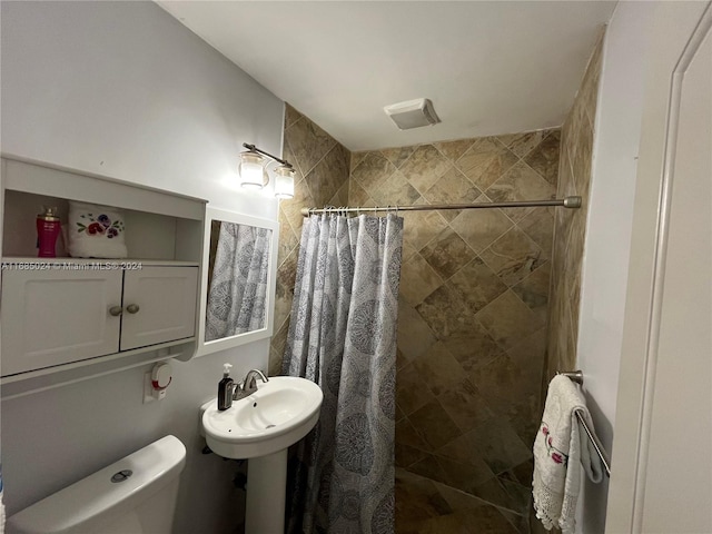 bathroom with toilet, curtained shower, and sink