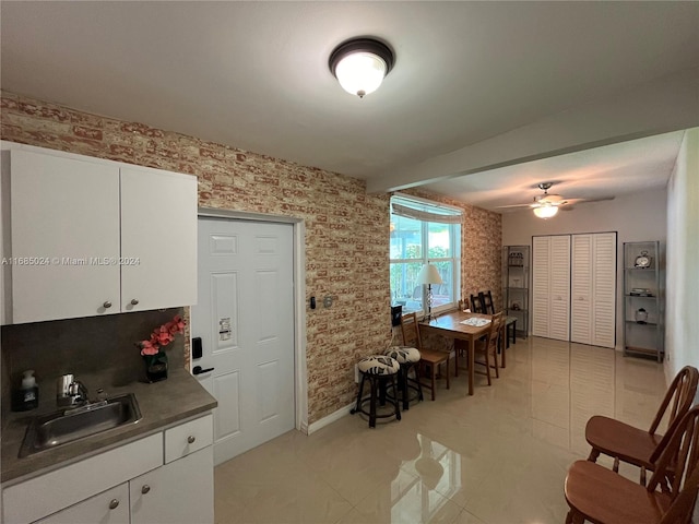 interior space with ceiling fan, sink, and light tile patterned floors