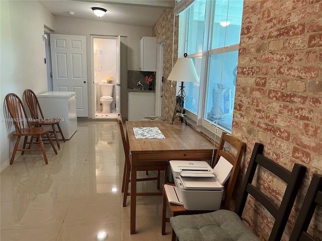 dining area with brick wall and sink