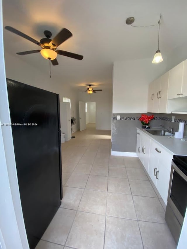 kitchen featuring sink, hanging light fixtures, light tile patterned floors, stainless steel electric range oven, and white cabinetry