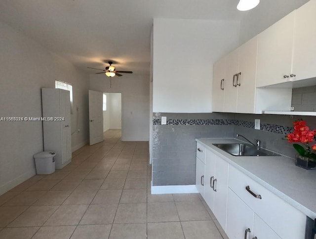 kitchen featuring light tile patterned floors, white cabinetry, ceiling fan, and sink