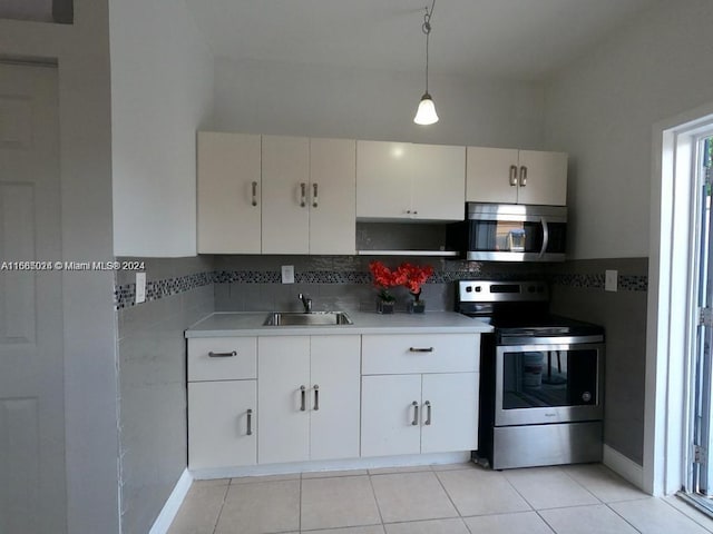 kitchen featuring white cabinets, appliances with stainless steel finishes, hanging light fixtures, and sink