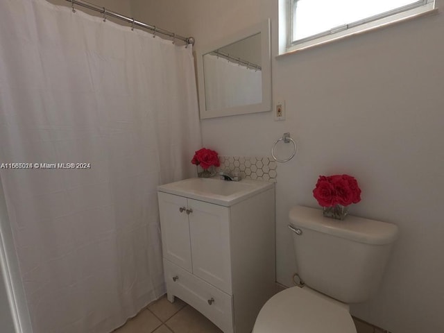 bathroom with toilet, vanity, and tile patterned floors