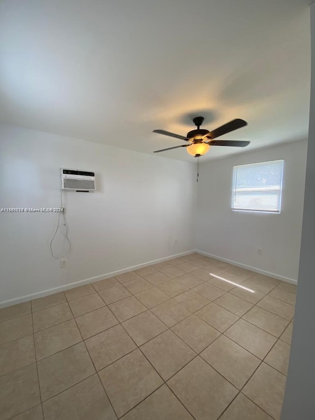 empty room with light tile patterned floors, a wall unit AC, and ceiling fan