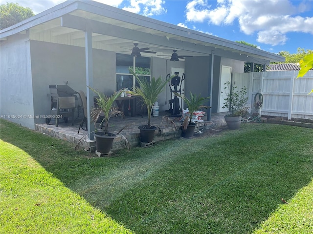 rear view of property featuring a lawn, ceiling fan, and a patio