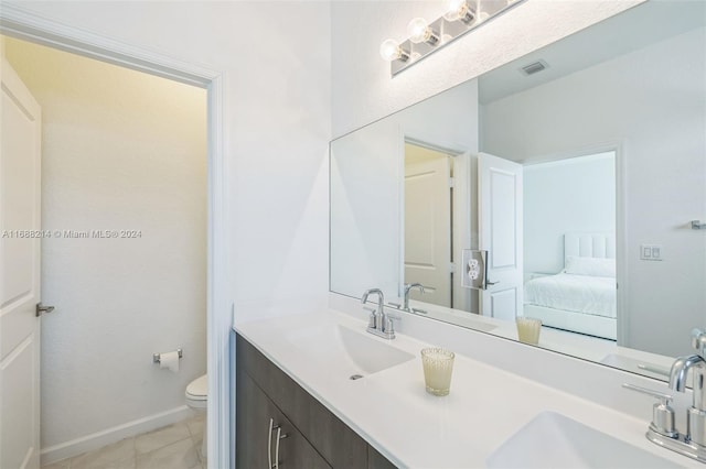 bathroom featuring tile patterned flooring, vanity, and toilet