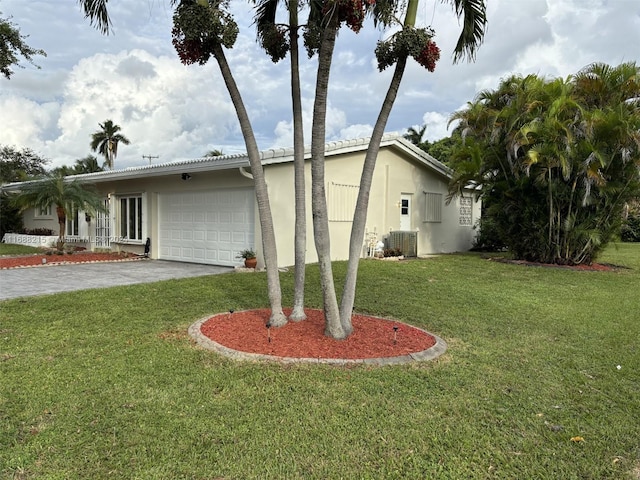 view of side of home featuring a garage, a yard, and central air condition unit