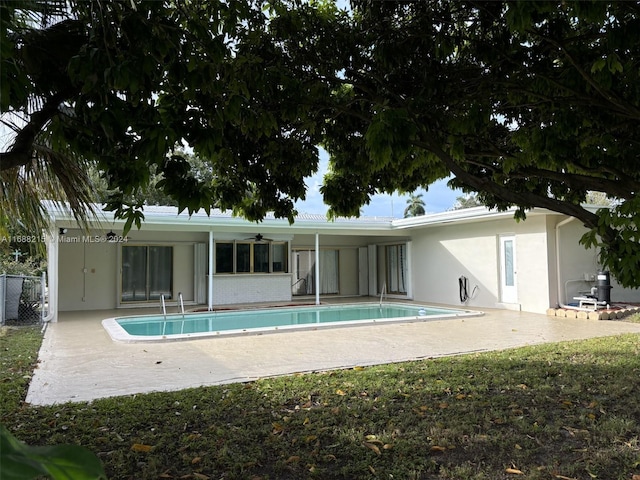 rear view of property featuring ceiling fan and a patio area