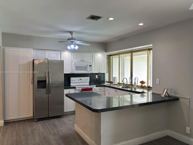 kitchen with hardwood / wood-style floors, white appliances, white cabinets, sink, and kitchen peninsula