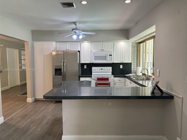 kitchen with white cabinetry, sink, dark hardwood / wood-style floors, kitchen peninsula, and white appliances