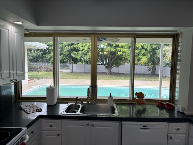 kitchen with dishwasher, white cabinets, stove, and sink