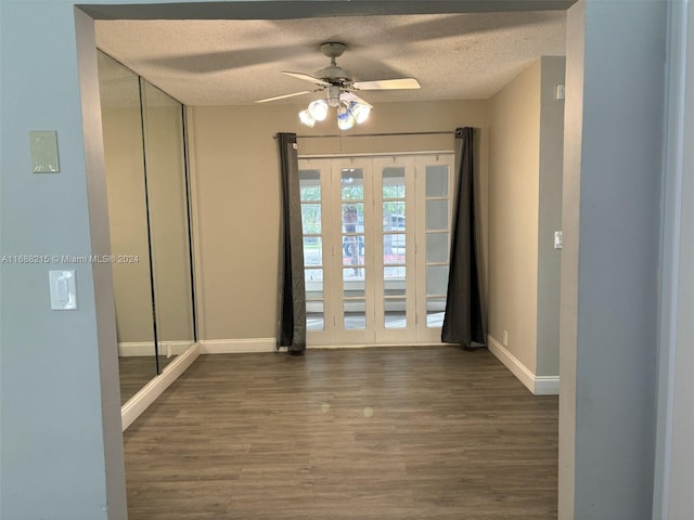 doorway to outside featuring a textured ceiling, ceiling fan, and dark wood-type flooring