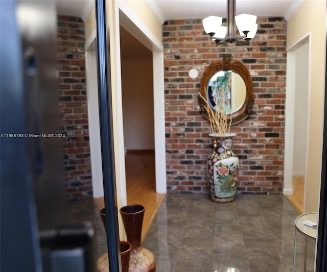 corridor with ornamental molding and brick wall