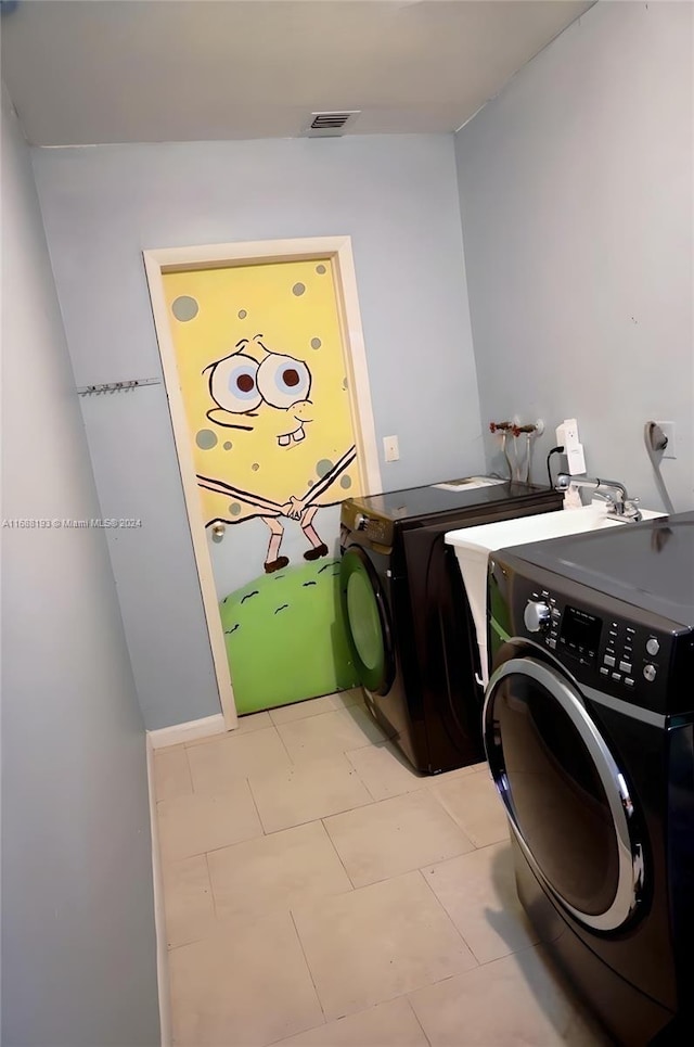 laundry room with washing machine and clothes dryer and light tile patterned floors