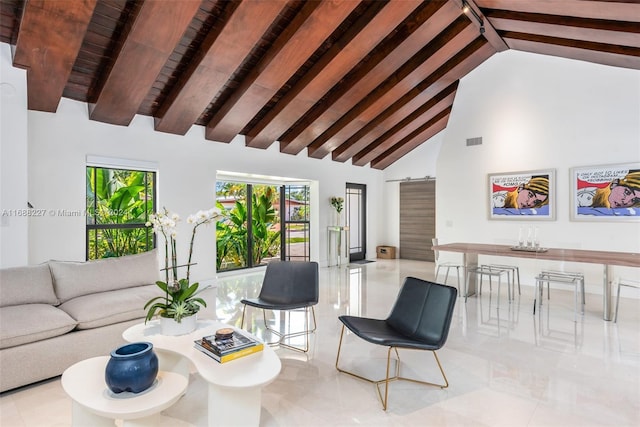 living room featuring beam ceiling, high vaulted ceiling, and a barn door