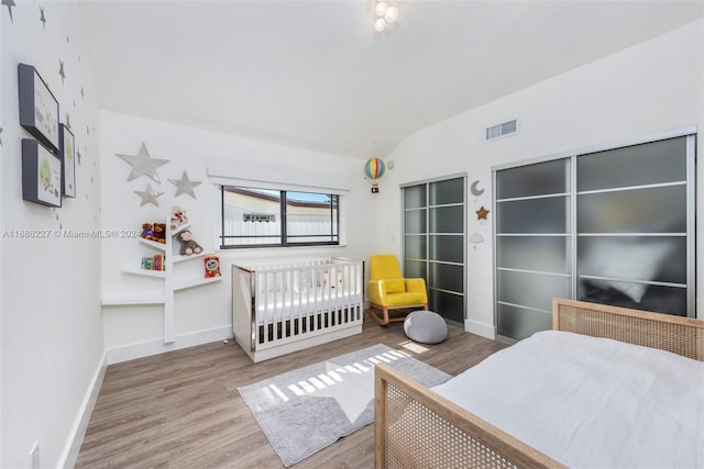 bedroom with lofted ceiling and wood-type flooring