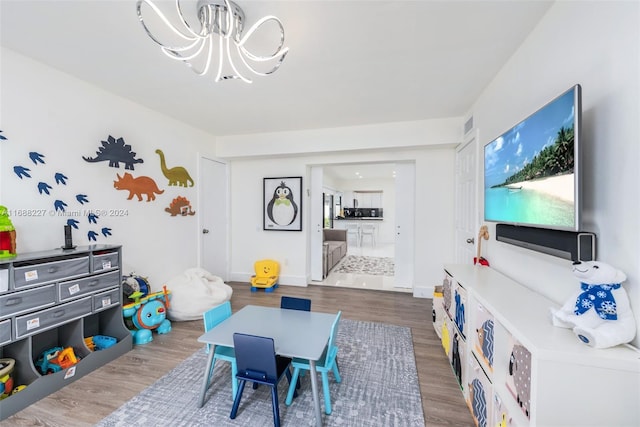 playroom featuring dark hardwood / wood-style floors and a chandelier