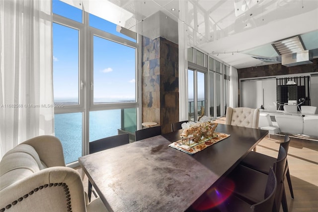 dining room featuring wood-type flooring and a water view