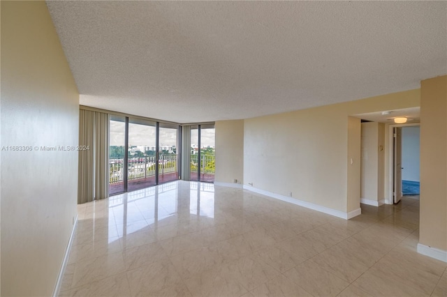 empty room featuring expansive windows and a textured ceiling