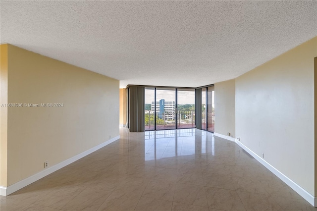 spare room featuring floor to ceiling windows and a textured ceiling