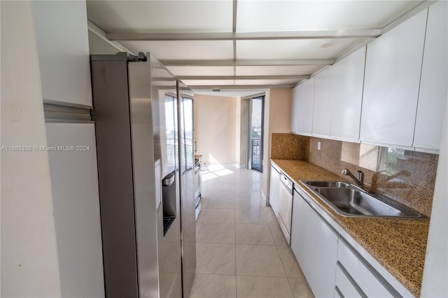 kitchen with dark stone counters, white dishwasher, decorative backsplash, sink, and white cabinetry