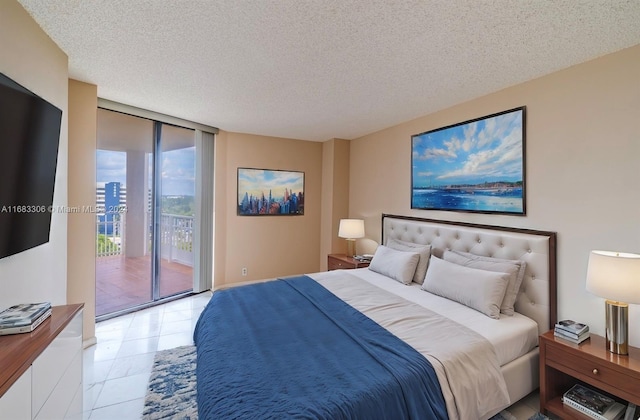 tiled bedroom with access to exterior, a textured ceiling, and floor to ceiling windows