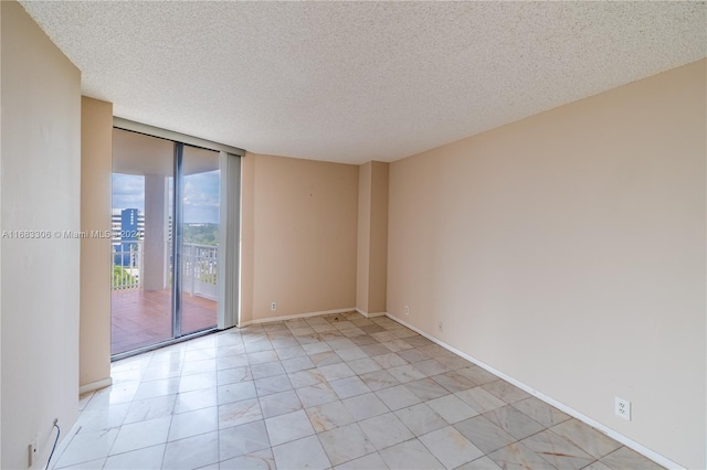 spare room with expansive windows and a textured ceiling