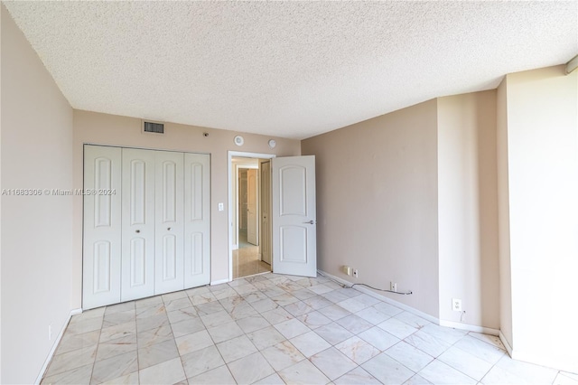 unfurnished bedroom featuring a closet and a textured ceiling