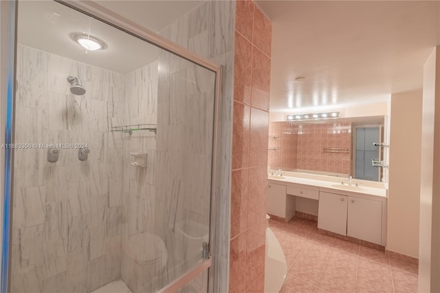 bathroom featuring a shower with shower door, vanity, and tile patterned flooring