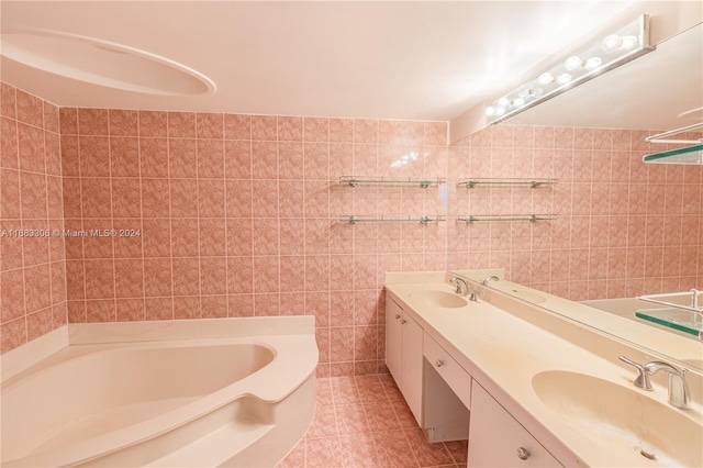 bathroom featuring vanity, a tub, tile patterned floors, and tile walls