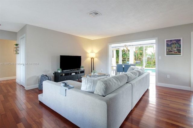 living room with dark hardwood / wood-style floors and a chandelier