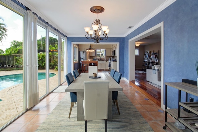 dining space with ornamental molding, light hardwood / wood-style flooring, and a chandelier