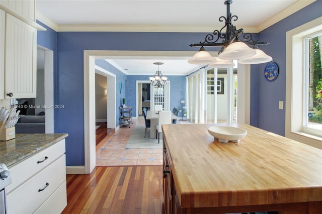 dining room featuring hardwood / wood-style flooring, ornamental molding, and a notable chandelier