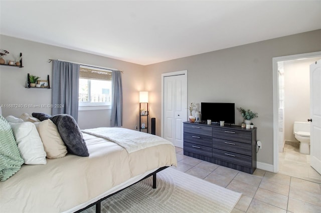 bedroom featuring light tile patterned floors, connected bathroom, and a closet