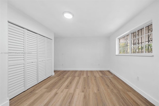 unfurnished bedroom with light hardwood / wood-style flooring and a closet