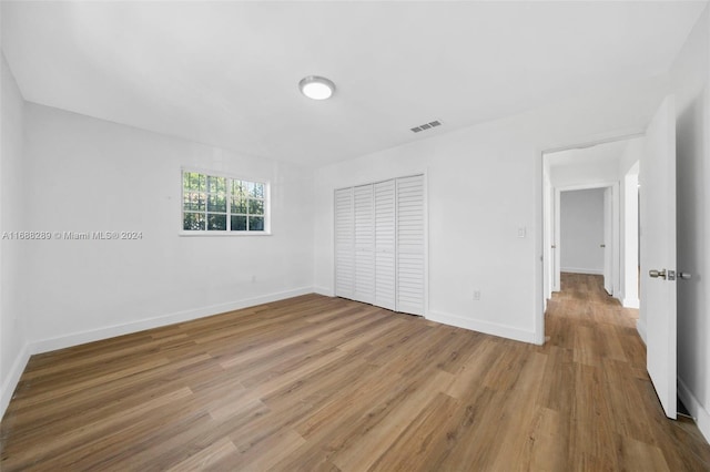 unfurnished bedroom with wood-type flooring and a closet