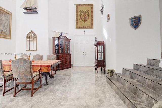 dining space featuring a towering ceiling