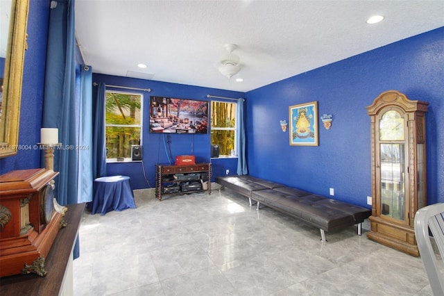 interior space with recessed lighting, ceiling fan, and a textured wall