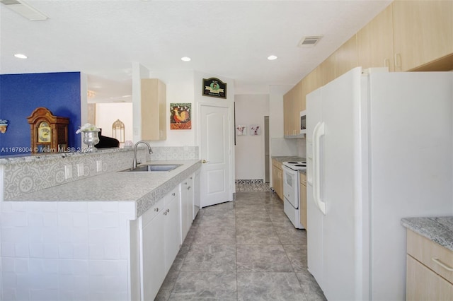 kitchen with white appliances, visible vents, a sink, a peninsula, and light countertops
