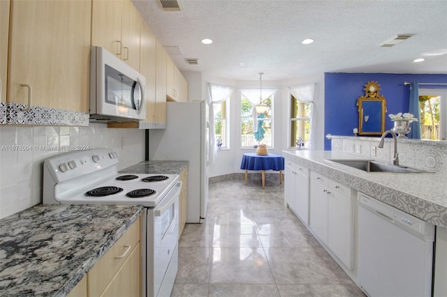 kitchen with sink, a textured ceiling, backsplash, hanging light fixtures, and white appliances