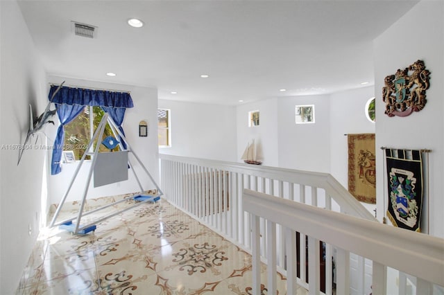 hall with a wealth of natural light, visible vents, an upstairs landing, and recessed lighting