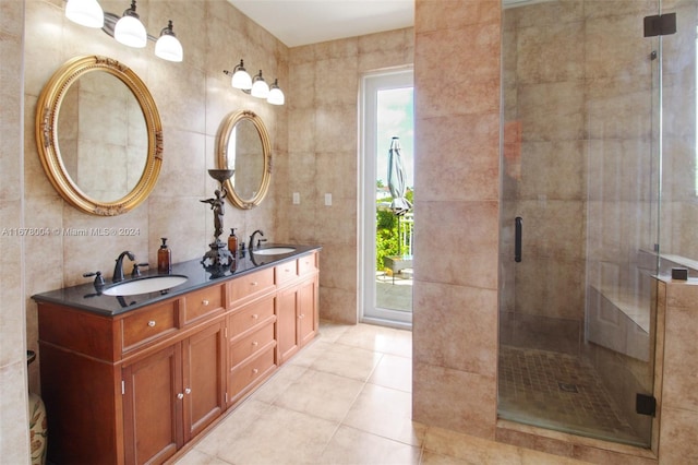 bathroom featuring tile walls, vanity, tile patterned flooring, and a shower with door